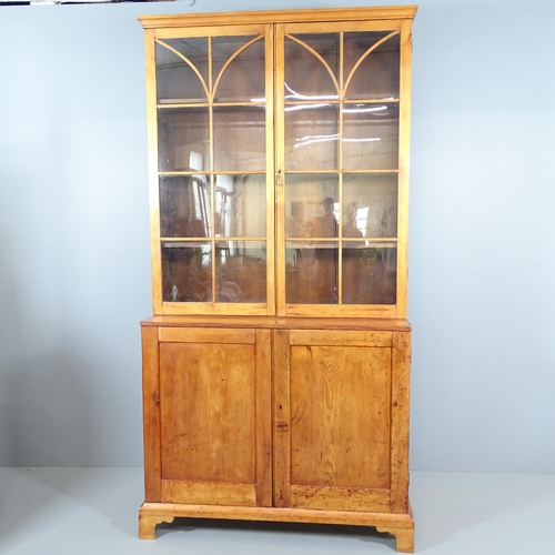 2268 - An antique pine two section bookcase, with two lattice glazed doors and cupboards under, raised on b... 