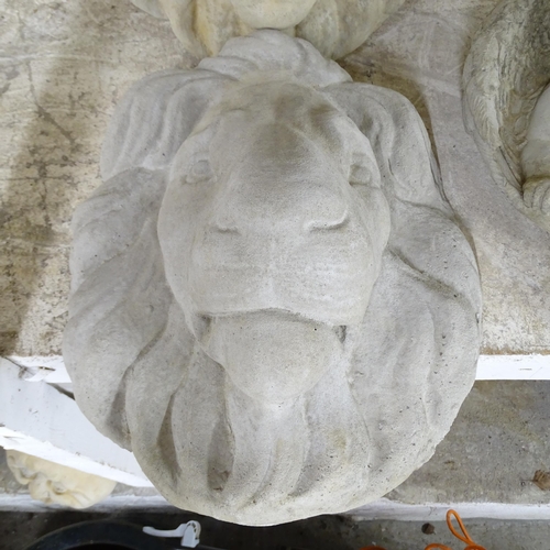 2574 - A pair of concrete lion wall masks. 34x40cm.