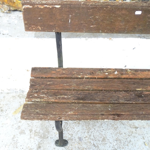 2599 - A weathered teak garden bench on wrought iron frame. 122x74x41cm.