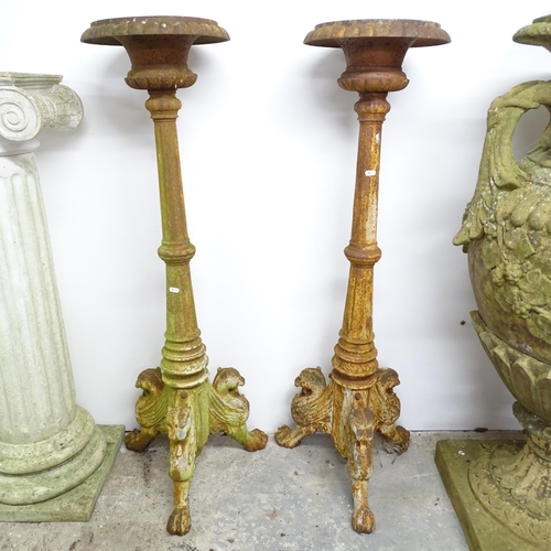 2623 - A pair of cast iron torchere stands, raised on griffin legs. Height 122cm.