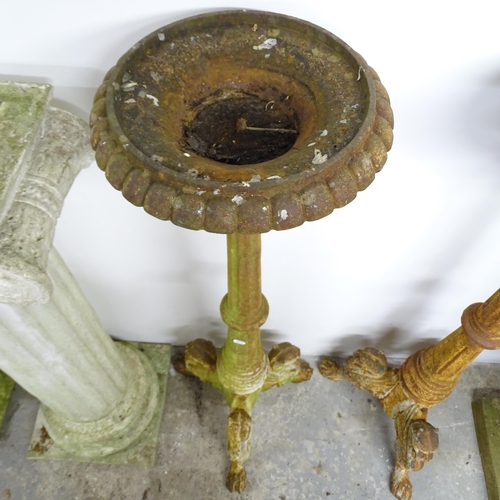 2623 - A pair of cast iron torchere stands, raised on griffin legs. Height 122cm.