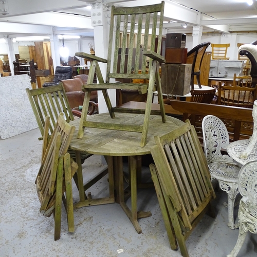 2640 - A weathered teak folding circular garden table, 121x76cm, with four matching folding chairs.