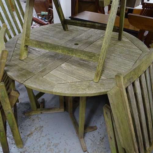 2640 - A weathered teak folding circular garden table, 121x76cm, with four matching folding chairs.