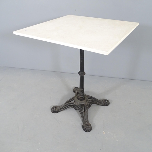 2655 - A square stone top garden table on cast iron base. 60x73cm.