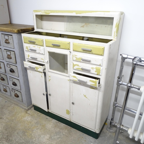 2694 - A vintage painted metal cabinet, with raised back, nine drawers and four cupboards. 98x130x37cm