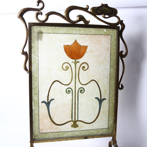 282 - An Art Nouveau brass-framed fire screen with an inset stylised glass panel, bead and wirework decora... 