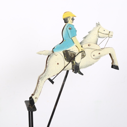 299 - An early 20th century painted balance polo player, metal and lead, the rider having articulated arms... 