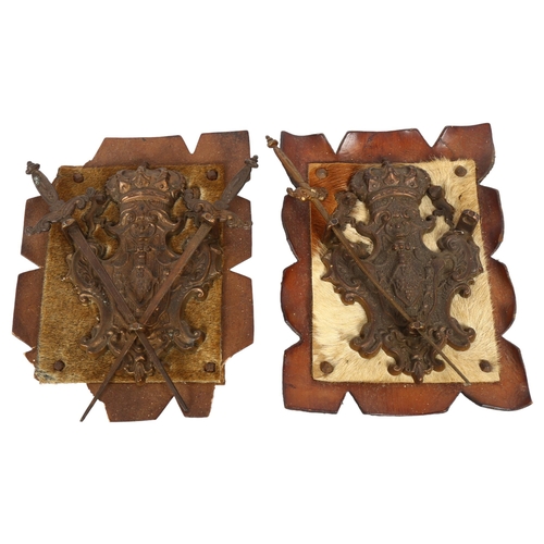 506 - A pair of cast-metal heraldic plaques with crossed swords, leather-mounted, overall height 23cm (1 s... 