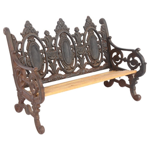 507 - A small embossed cast-iron doll's bench, with oval panelled back, L40cm, H26cm