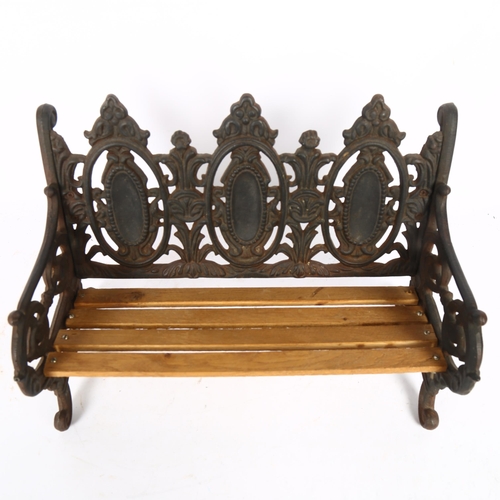 507 - A small embossed cast-iron doll's bench, with oval panelled back, L40cm, H26cm