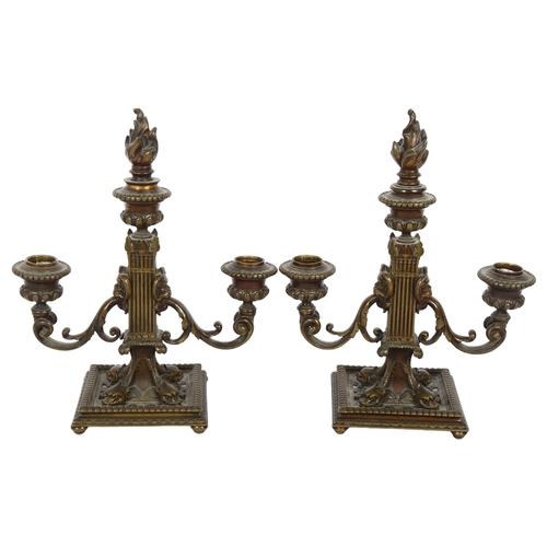 513 - A pair of ornate cast-brass 2-branch table candelabras, with flame finials and dolphin supports on a... 