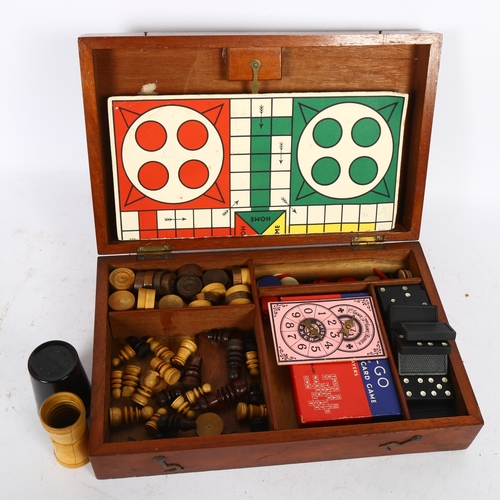 525 - A mahogany boxed games compendium, including dominos, draughts, and chess set etc