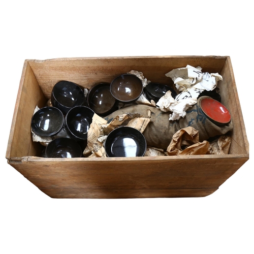 632 - A large quantity of black lacquered Oriental bowls in a large wooden crate with associated lid. Crat... 