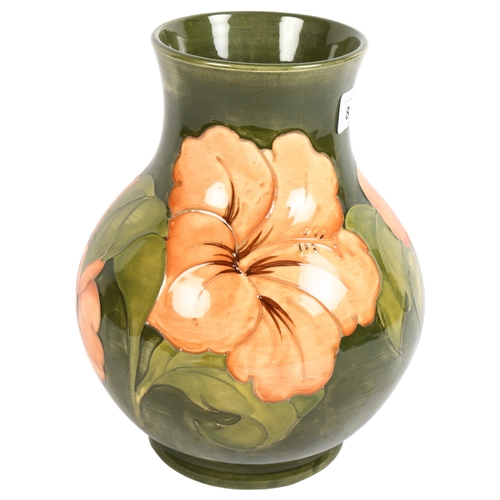 873 - Moorcroft green ground vase with Hibiscus design, signed, with paper label, H24cm