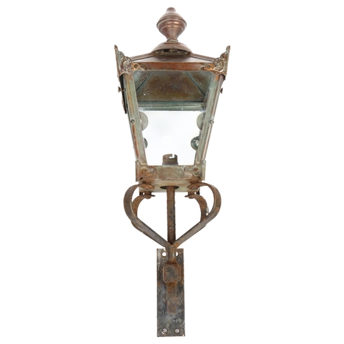 624 - A Victorian style wall hanging lantern with cast-iron bracket and brass or copper casing. H - 56cm.