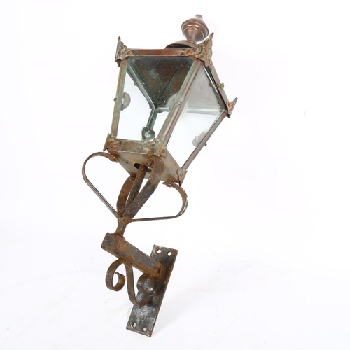 624 - A Victorian style wall hanging lantern with cast-iron bracket and brass or copper casing. H - 56cm.