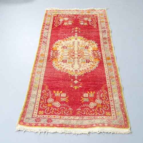 2308 - A red-ground Persian style rug. 176x86cm.