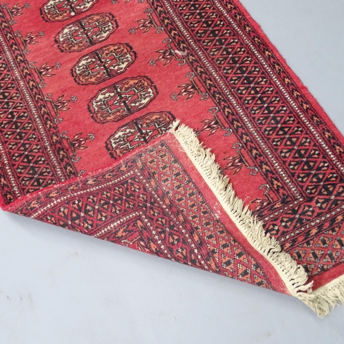 2313 - A red-ground Bokhara runner. 280x80cm