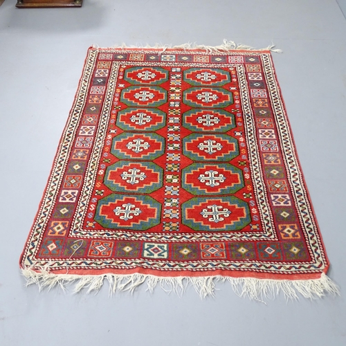 2315 - A red-ground wool rug with Afghan design. 155x110cm.