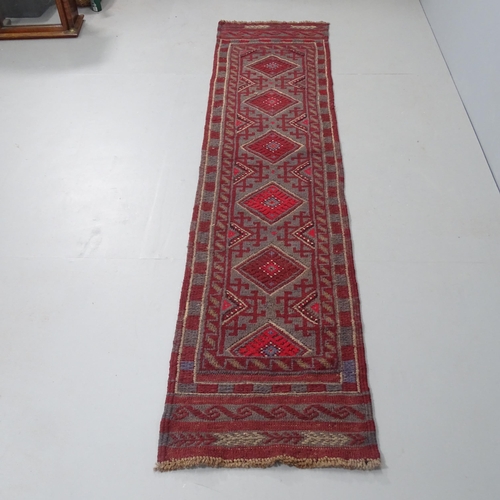 2323 - A red-ground Meshwani runner. 248x53cm