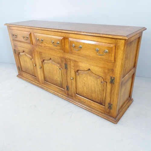 2695 - A reproduction oak sideboard, with three frieze drawers and cupboards under. 168x83x47cm.