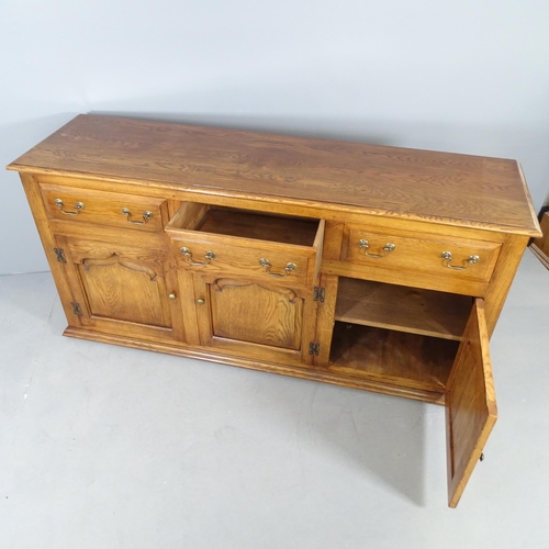 2695 - A reproduction oak sideboard, with three frieze drawers and cupboards under. 168x83x47cm.