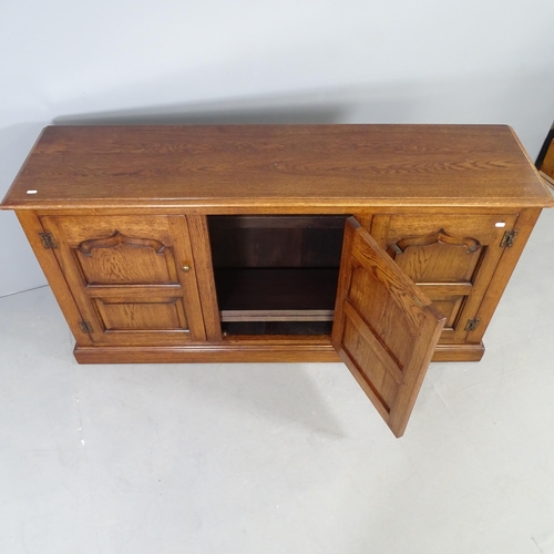 2696 - A reproduction oak dresser base, with three fielded panelled doors and shelved interior. 153x79x42cm... 