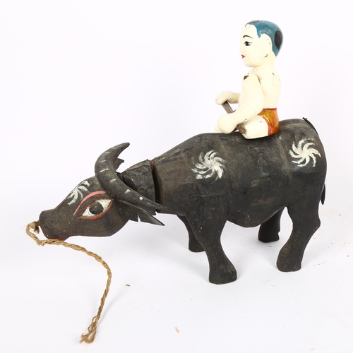 683 - A carved and painted wood Oriental water buffalo and rider, L30cm