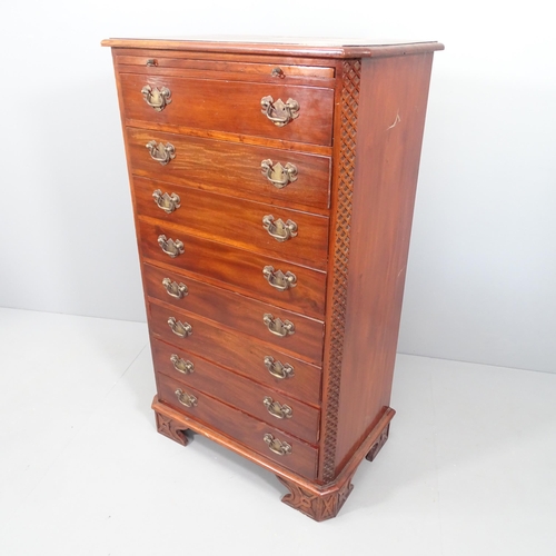 2055 - A reproduction mahogany chest of eight drawers, with brushing slide, carved decoration and bracket f... 