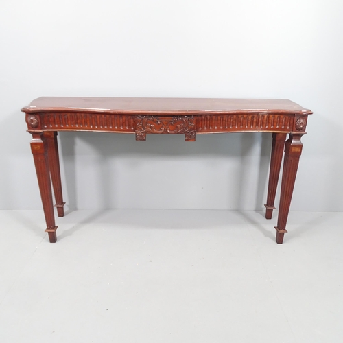 2077 - An antique mahogany console table of serpentine front, with carved decoration and raised on square t... 