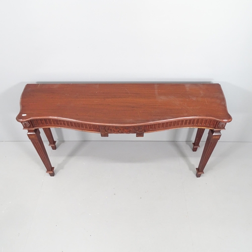 2077 - An antique mahogany console table of serpentine front, with carved decoration and raised on square t... 