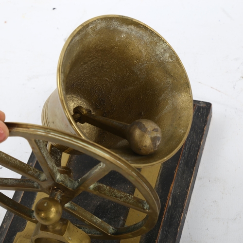 101 - A novelty cast-brass desk bell, on ebonised base, width 18cm