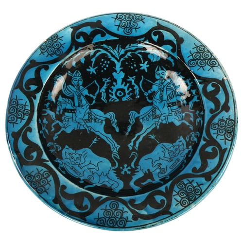 110 - An Islamic blue ground glazed pottery bowl, decorated with hunting scenes, diameter 30cm