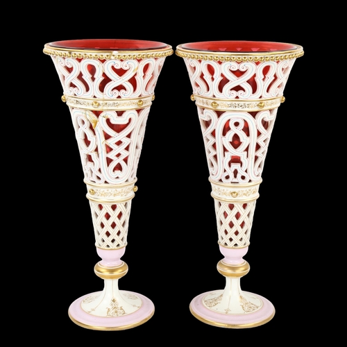 118 - A pair of late 19th century pierced white glaze porcelain vases, with gilded decoration and cranberr... 