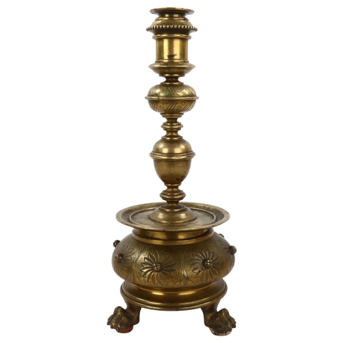 136 - A 19th century brass candle stand on brass lion paw feet, height 32cm