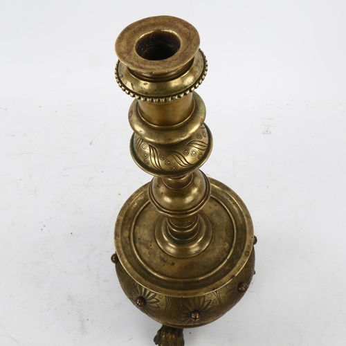 136 - A 19th century brass candle stand on brass lion paw feet, height 32cm