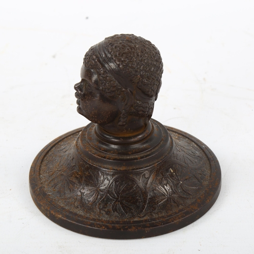 162 - A 19th century patinated iron paperweight, surmounted by a man's head, diameter 10cm