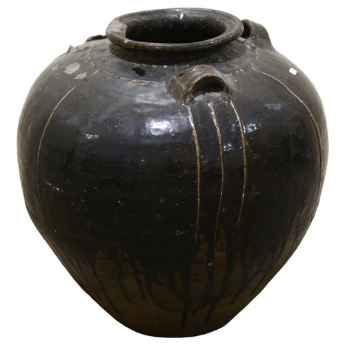 20 - A large Burmese treacle glaze pottery jar, with shoulder ring handles, height 55cm