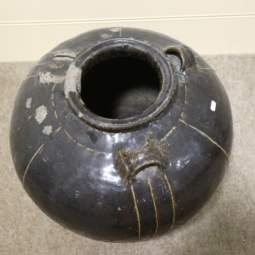 20 - A large Burmese treacle glaze pottery jar, with shoulder ring handles, height 55cm