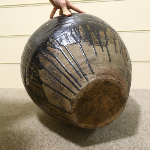 20 - A large Burmese treacle glaze pottery jar, with shoulder ring handles, height 55cm