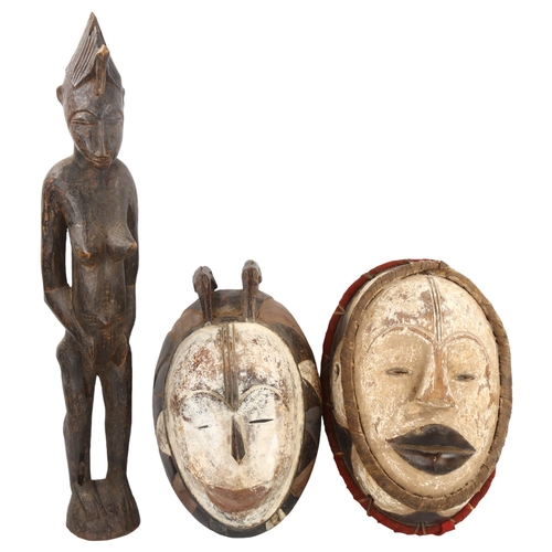 91 - 2 African Tribal carved and painted wood masks, length 36cm, and a carved wood standing fertility fi... 