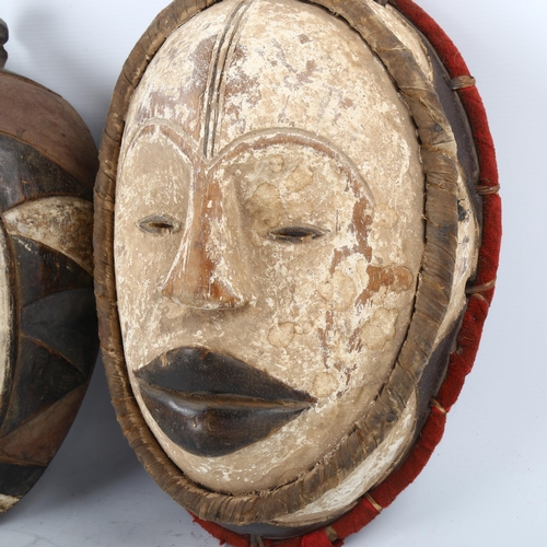 91 - 2 African Tribal carved and painted wood masks, length 36cm, and a carved wood standing fertility fi... 