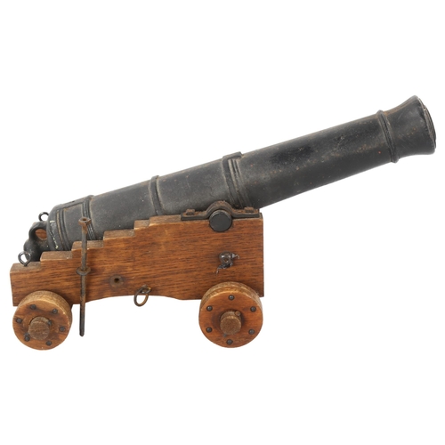 95 - A Victorian iron table cannon on wheeled wooden carriage base, barrel length 39cm