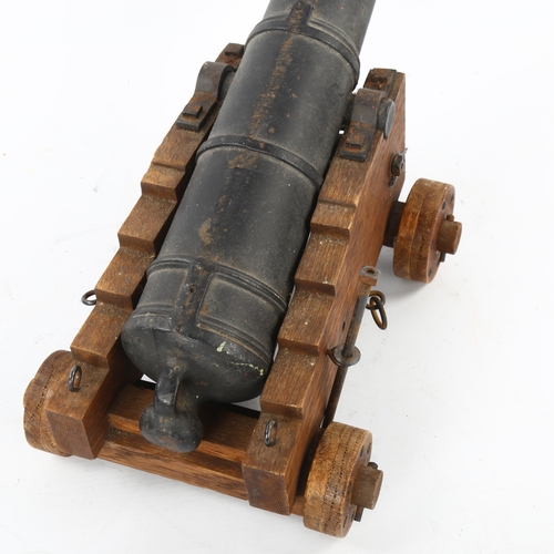 95 - A Victorian iron table cannon on wheeled wooden carriage base, barrel length 39cm