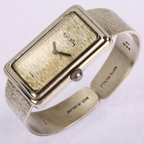1040 - ROY KING - a lady's sterling silver quartz bangle watch, textured silver dial with textured bangle s... 