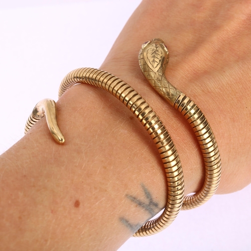 1100 - A mid-20th century 9ct gold ruby figural coiled snake bangle, with engraved head and gas-pipe body, ... 