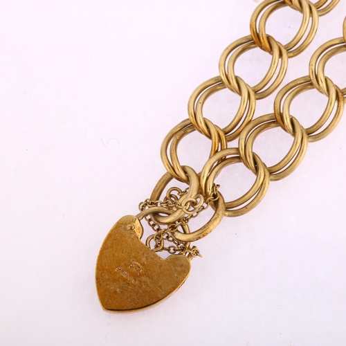 1132 - A late 20th century 9ct gold double curb link chain bracelet, with 9ct heart padlock, maker's marks ... 