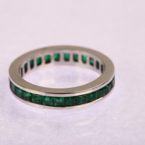 1163 - A modern 18ct white gold emerald full eternity ring, channel set with square step-cut emeralds, band... 