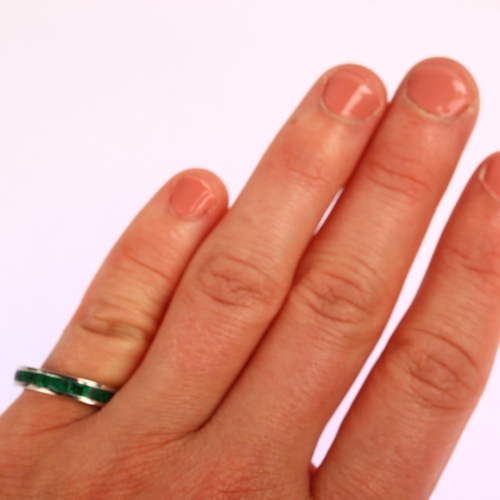 1163 - A modern 18ct white gold emerald full eternity ring, channel set with square step-cut emeralds, band... 