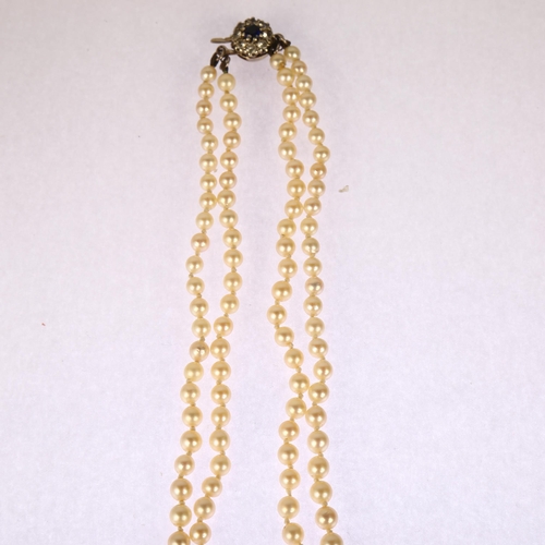 1204 - A mid-20th century graduated double-strand cultured pearl necklace, with 9ct white gold stone set cl... 